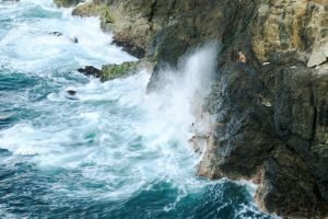 un groupe de personnes debout au sommet d'une falaise à côté de l'océan