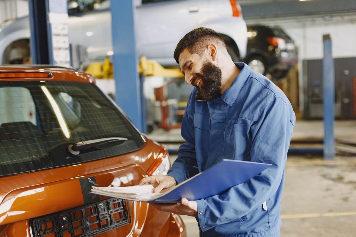 Mécanicien avec un véhicule rouge en garage, feuille de travail Mécanicien avec un véhicule rouge en garage, feuille de travail