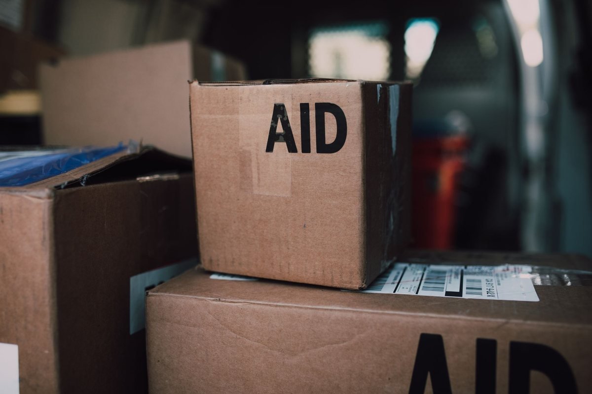 Cartons d'aide humanitaire empilés dans un espace de stockage
